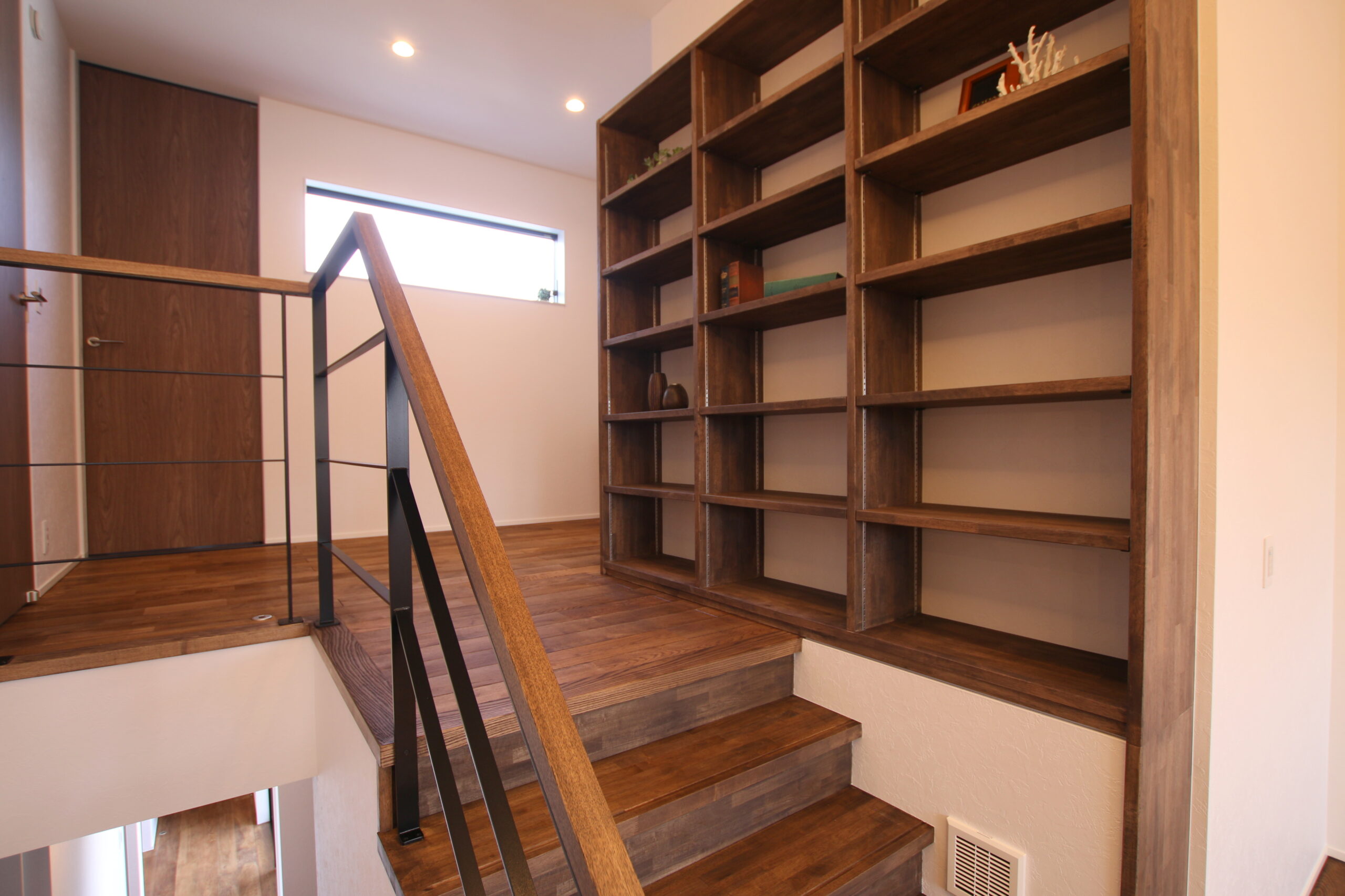 ２Fへ上がる階段部に造作本棚を設け、ふとした時に本をとれる動線中に計画。